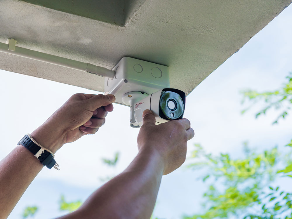 Electrician installing an outdoor CCTV security camera as part of electrical and security works