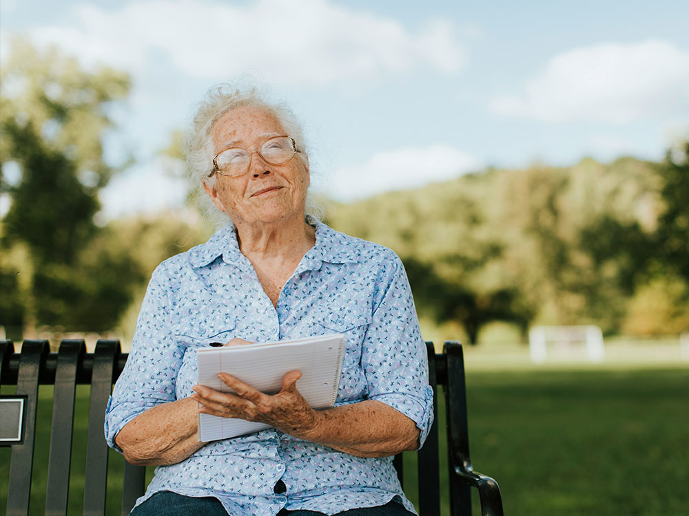 Senior resident enjoying a well-maintained public park delivered through grounds maintenance services