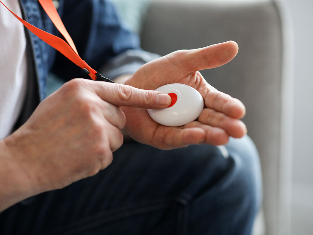 Supported living resident holding a personal telecare panic button