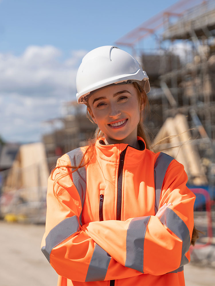Female construction manager in orange high-visibility jacket on a new build development site