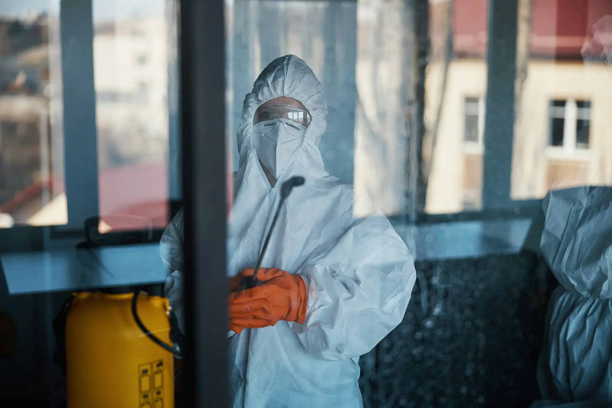 Someone in a protective suit spraying a screen.